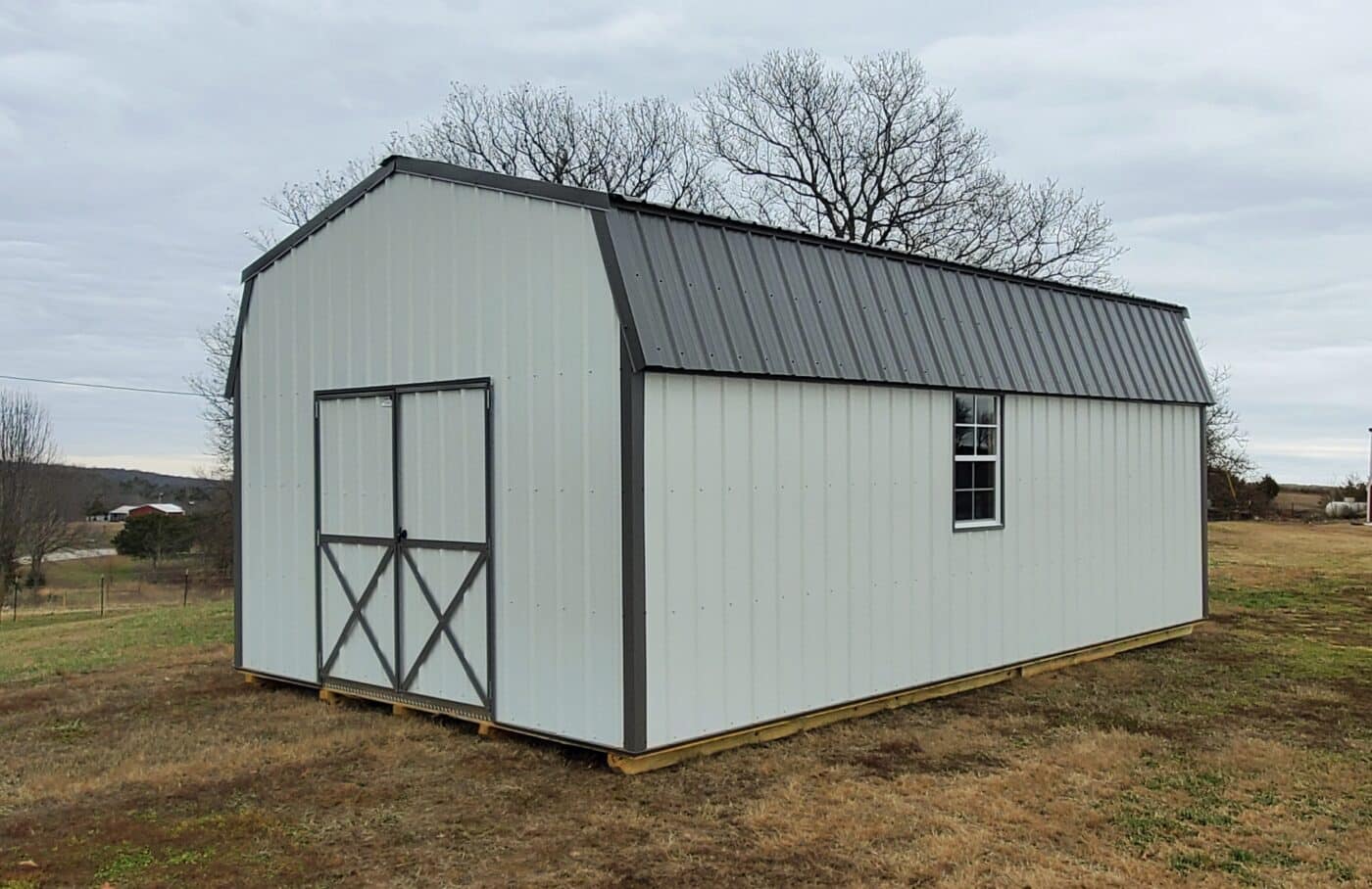white lofted barn with black trim sold by ozark premier buildings