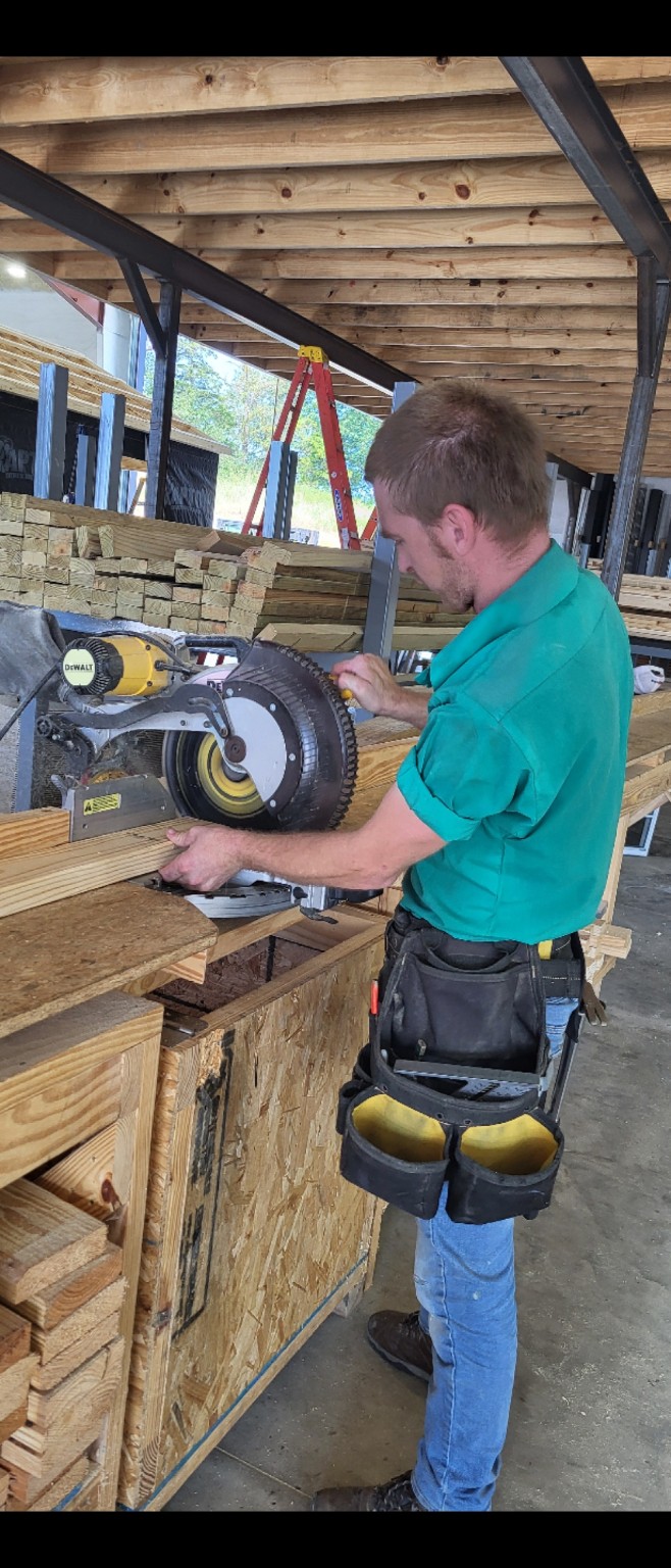 Jacob working with lumber at Ozark Premier Buildings