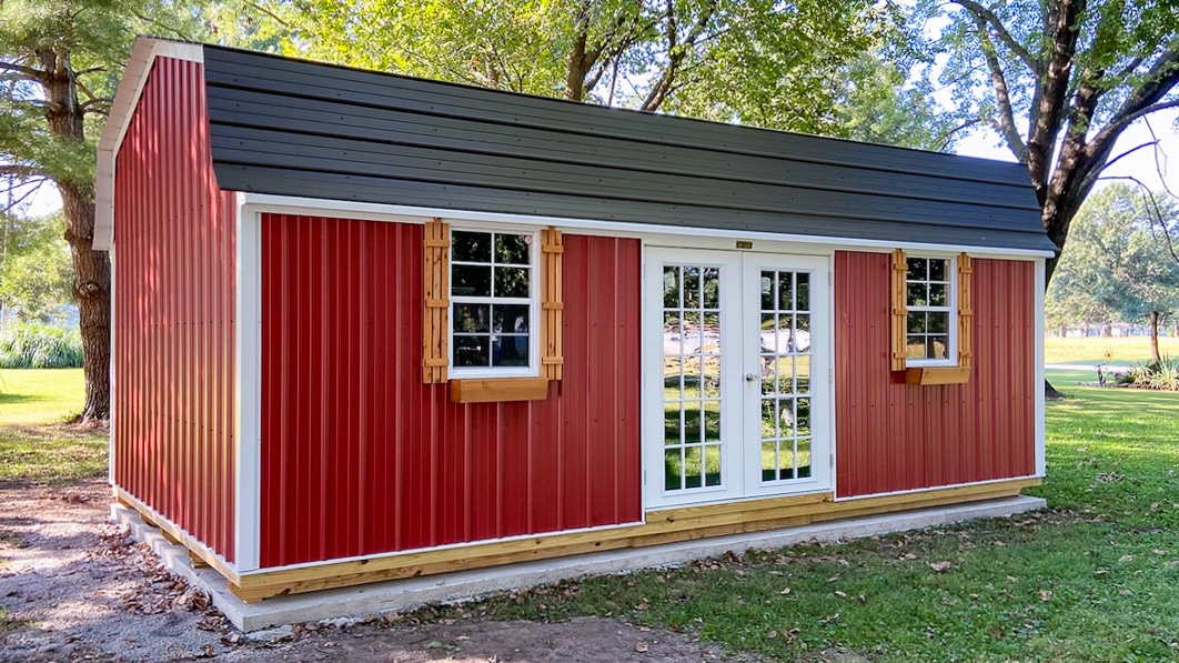 Large shed with red metal siding and black metal roofing for sale in Arkansas after delivery